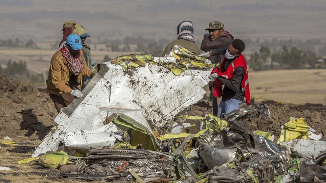 Workers remove debris from the Ethiopian Airlines crash site south of Addis Ababa on Monday. Picture: AP