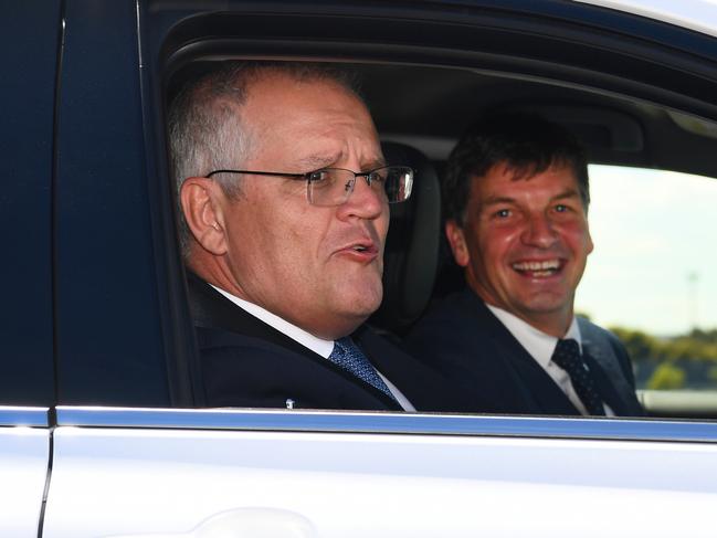 Australian prime minister Scott Morrison (L) and Australia's Minister for Energy and Emissions Reduction Angus Taylor (R) drive a hydrogen-fuelled car around a Toyota test track in Melbourne in Melbourne on November 9, 2021.  Morrison visits the Toyota Hydrogen Centre in Altona to unveil a new $250m electric vehicle plan.