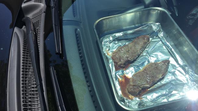 Well done or rare? Max Wooldridge cooks steak in his Monaro during Adelaide’s hot weather.