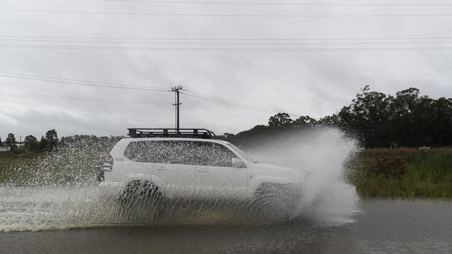 A driver braves flood waters in Pitt Town. Picture: Getty