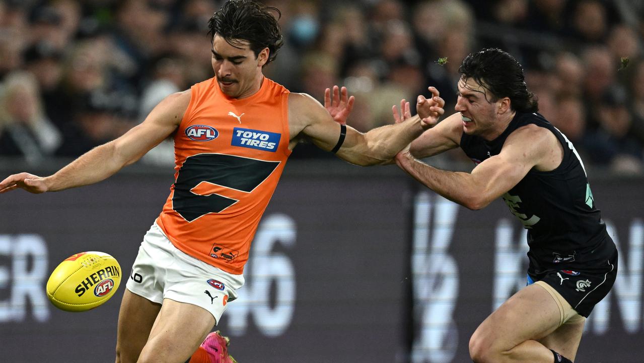 MELBOURNE, AUSTRALIA – AUGUST 27: Toby Bedford of the Giants kicks whilst being tackled by Oliver Hollands of the Bluesduring the round 24 AFL match between Carlton Blues and Greater Western Sydney Giants at Marvel Stadium, on August 27, 2023, in Melbourne, Australia. (Photo by Quinn Rooney/Getty Images)