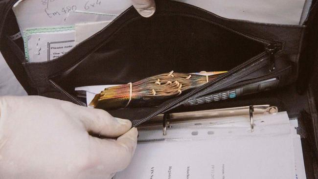 Cash inside a black folder found inside the warehouse. Picture released by Supreme Court.