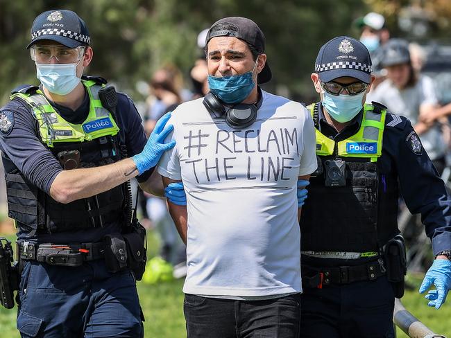 A Reclaim the Line protester is lead away by police at Maribyrnong Park. Picture: Ian Currie