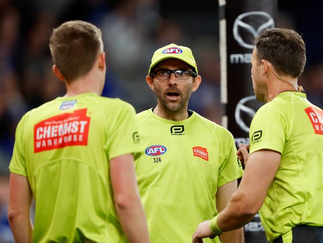 AFL goal umpire Daniel Hoskin speaks to colleagues on the goal-line. Picture: Dylan Burns/AFL Photos via Getty Images.