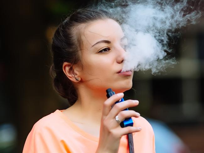 Pretty young girl vape popular ecig gadget,vaping device.Happy brunette vaper girl with e-cig.Portrait of smoker female model with electronic cigarette vaporizer.Ejuice vaping with fruit flavor liquid i STOCK IMAGE