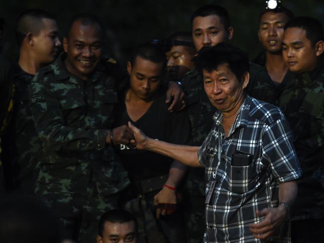 A father of one of the missing children thanks soldiers near Tham Luang cave.