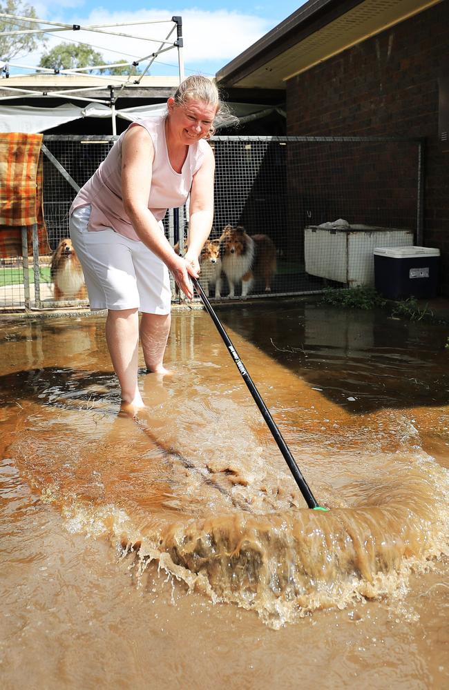 Coulson resident Bernadette Lions struggles to sweep out mud and water around her house after quickly rising flood waters broke the banks of Teviot Brook due to heavy rain fall which fell over the region. NCA NewsWire / Scott Powick