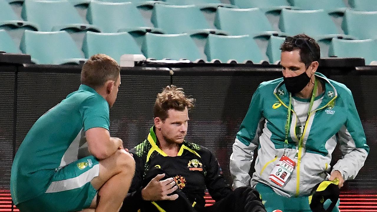 Australia's Steve Smith (C) gets medical attention as he hits his head against the ground in an attempt to catch the ball during the second T20 international cricket series match between Australia and Sri Lanka at the Sydney Cricket Ground (SCG) on February 13, 2022, in Sydney. (Photo by Muhammad FAROOQ / AFP) / -- IMAGE RESTRICTED TO EDITORIAL USE - STRICTLY NO COMMERCIAL USE --