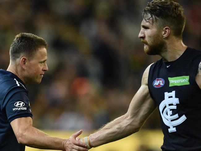 Carlton Blues coach Brendon Bolton (left) slaps hands with Zach Tuohy at three quarter time as the Blues play the Richmond Tigers in round one of the AFL at the MCG in Melbourne, Thursday, March 24, 2016. (AAP Image/Julian Smith) NO ARCHIVING, EDITORIAL USE ONLY