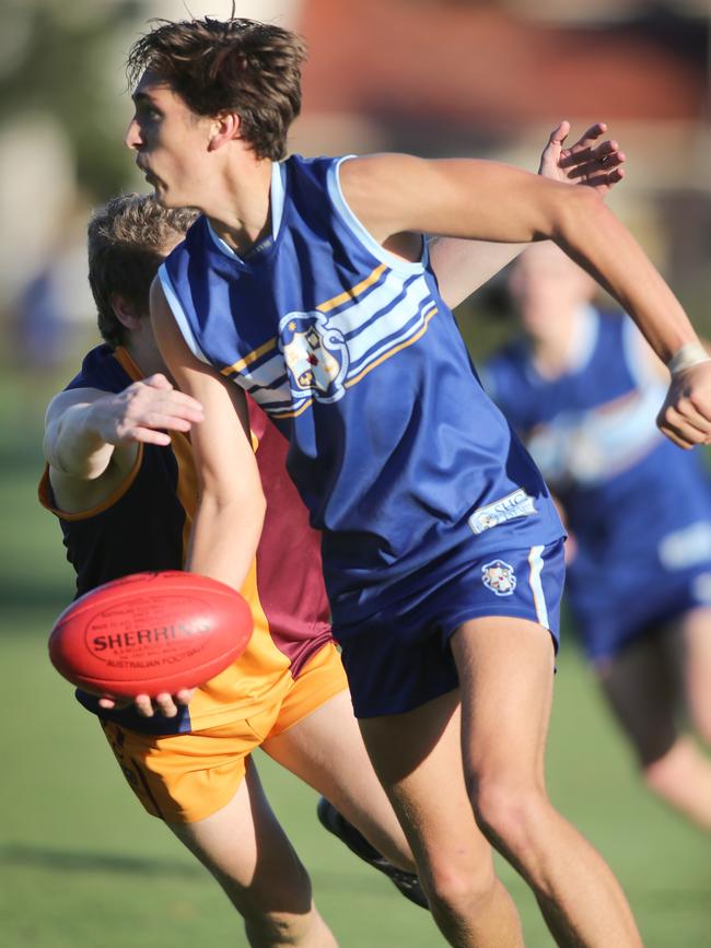 Zac Dumesny gets a handball away for Sacred Heart. Picture: AAP/Dean Martin