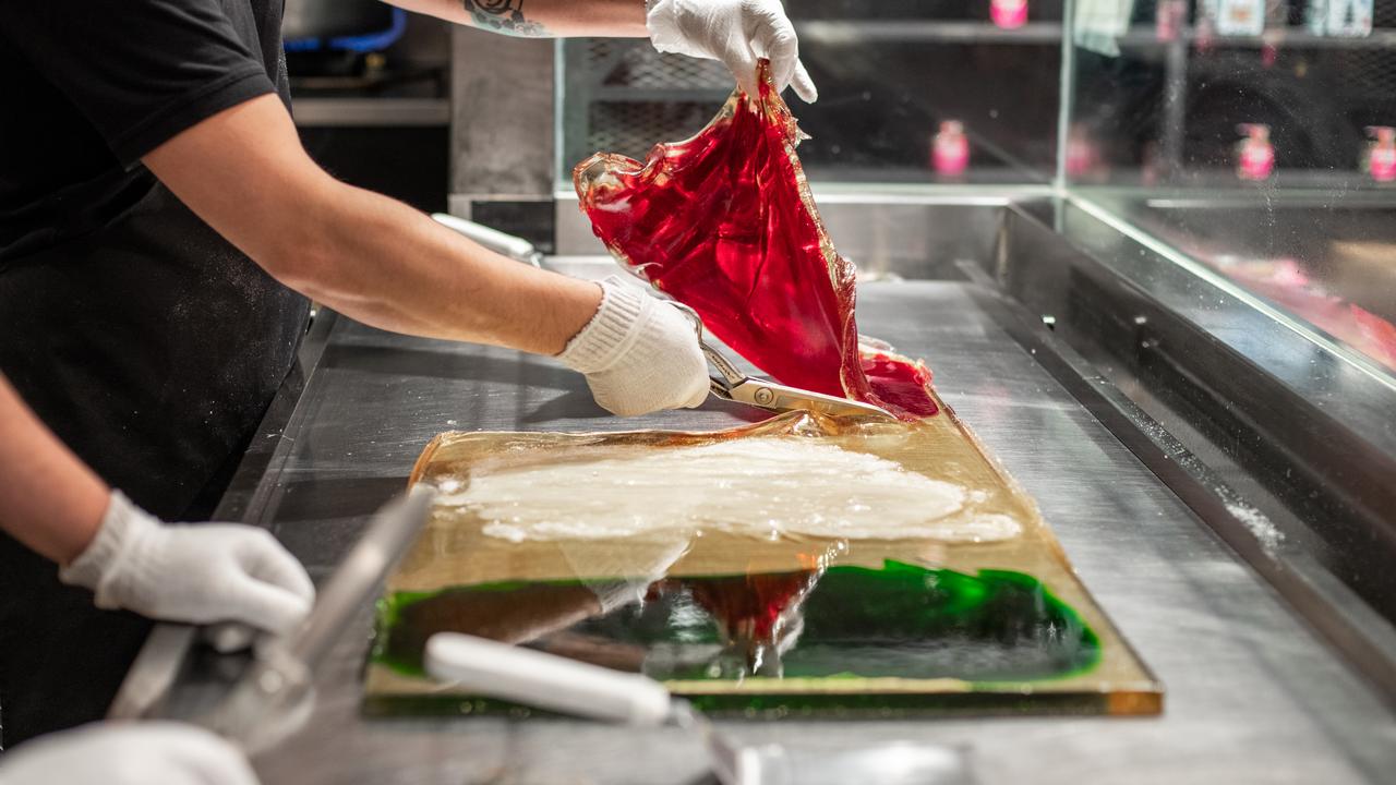 Workers cut the candy while it is still hot to meld it into shapes.