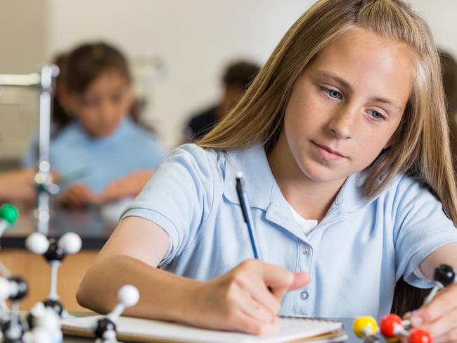 CAREERS: Preteen girl using atom educational toy in science class