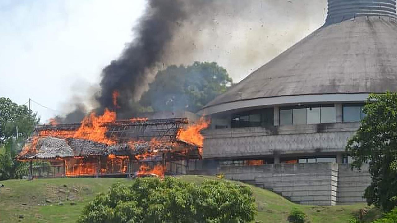 A building burning next to the parliament in Honiara during the rioting in November. Picture: AFP