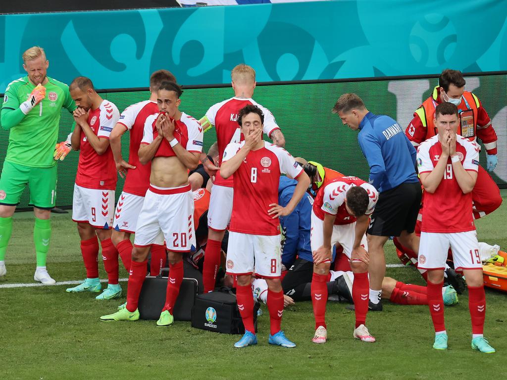 Christian Eriksen’s teammates form a barrier.