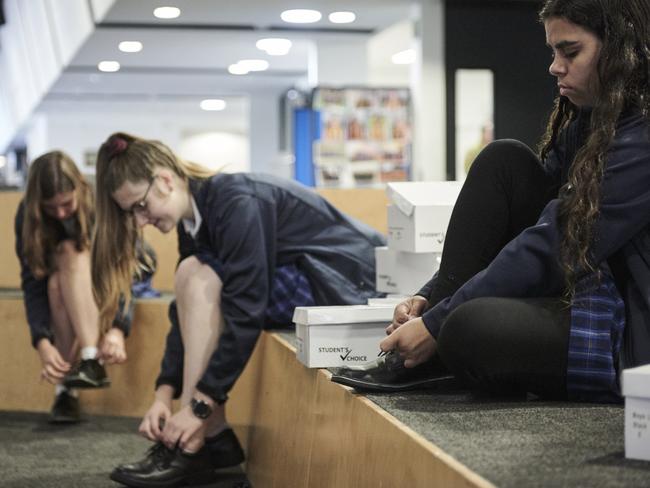 Chloe Long, Hannah Borland and Leteisha Bryant try on school shoes at Bairnsdale Secondary College.