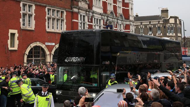 A drink can hits the screen of the Manchester United team bus.