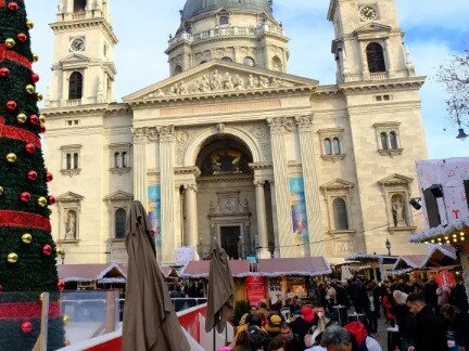 Budapest christmas market with christmas tree, market stalls and St. Stephen's Basilica with added snowflakes; advent basilica christmas market is one of Europe's most beautiful Christmas markets.