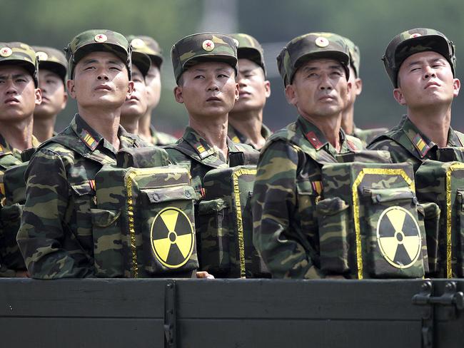 North Korean soldiers carrying packs marked with the nuclear symbol turn and look towards leader Kim Jong Un during a military parade in Pyongyang. Picture: AP