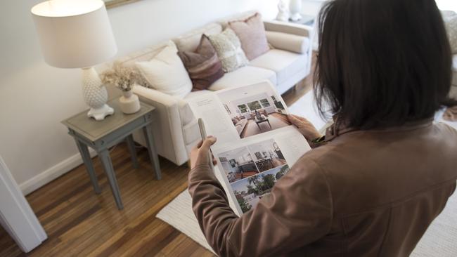 A woman browses a real estate pamphlet. Average rents across Australia’s major cities increased 11.5 per cent over the 12 months through June. Picture: Brent Lewin/Bloomberg via Getty Images