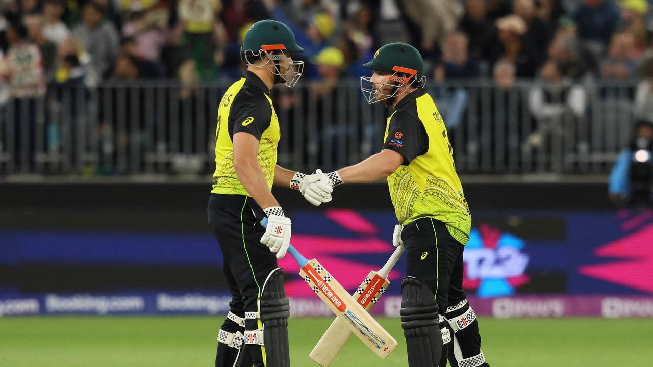 Australia's Aaron Finch (R) and Marcus Stoinis bump gloves at Perth Stadium on October 25, 2022 in Perth. Photo: AFP