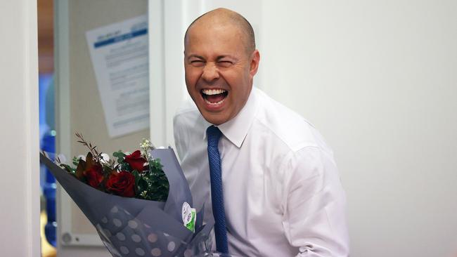 Josh Frydenberg had a joke with photographers about the flowers he received from two female cleaners who he has known for a long time, on the morning of the 2022 Budget at Parliament House in Canberra. Picture: NCA NewsWire / Gary Ramage