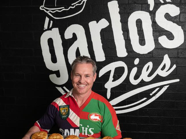 SYDNEY, AUSTRALIA - September 22:  Sean Garlick poses for a portrait holding a tray of his pies and wearing a half Sydney Roosters and half South Sydney RabbitohÃs jersey at the GarloÃs Pies Factory in Kingsgrove, Sydney. (Photo by James Gourley/The Daily Telegraph)