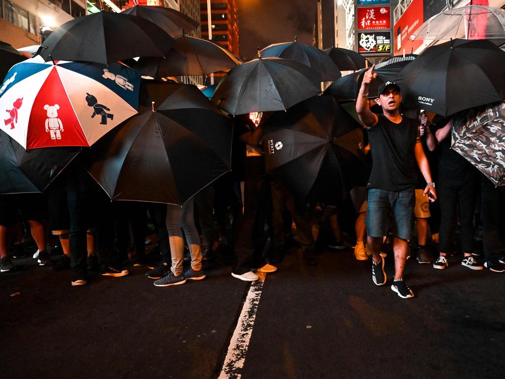 Protesters carry umbrellas to protect themselves as they face the police outside the West Kowloon railway station during a demonstration against a proposed extradition bill in Hong Kong. Picture: AFP
