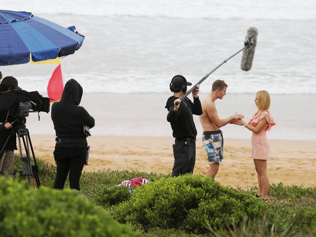 The not-so-glamorous side of TV: Raechelle shooting a <i>Home and Away</i> scene with Scott Lee on a wintry Palm Beach. Picture: Stephen Cooper