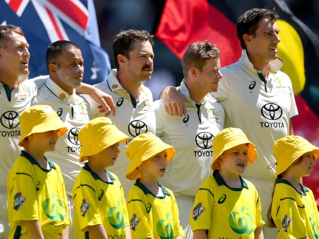 BRISBANE, AUSTRALIA - JANUARY 25: The Australian players embrace for the national anthem during day one of the Second Test match in the series between Australia and West Indies at The Gabba on January 25, 2024 in Brisbane, Australia. (Photo by Bradley Kanaris/Getty Images)