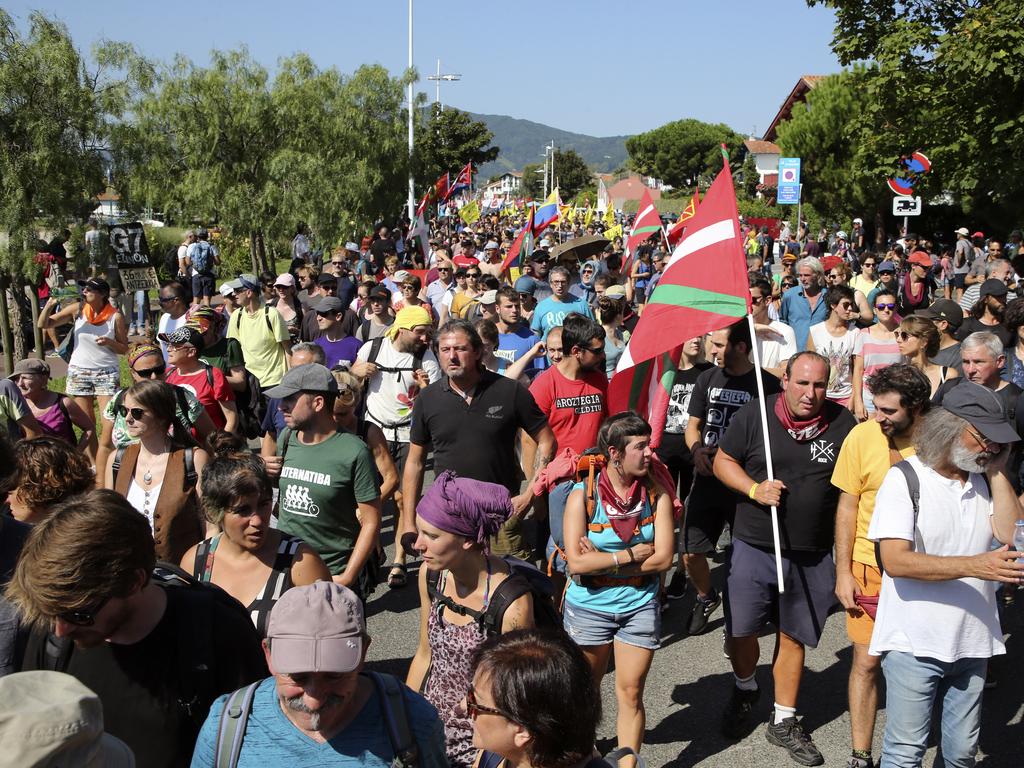 Anti-G-7 activists, some carrying Basque flags, walk on a road during a protest in Hendaye, France, Saturday. Picture: AP