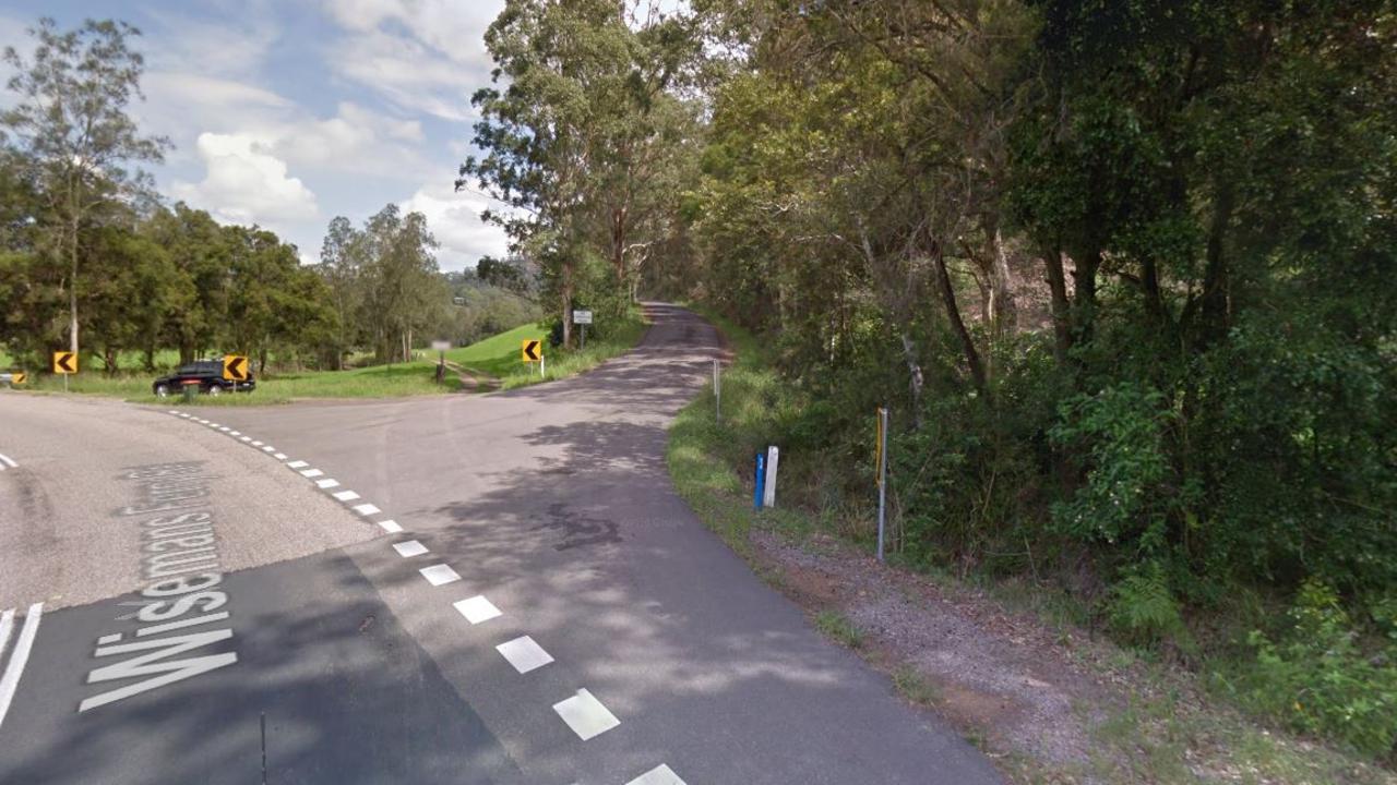 The turn-off to Mangrove Creek Road, up which a passing motorist spotted a body lying in leaves beneath a canopy of eucalypts.