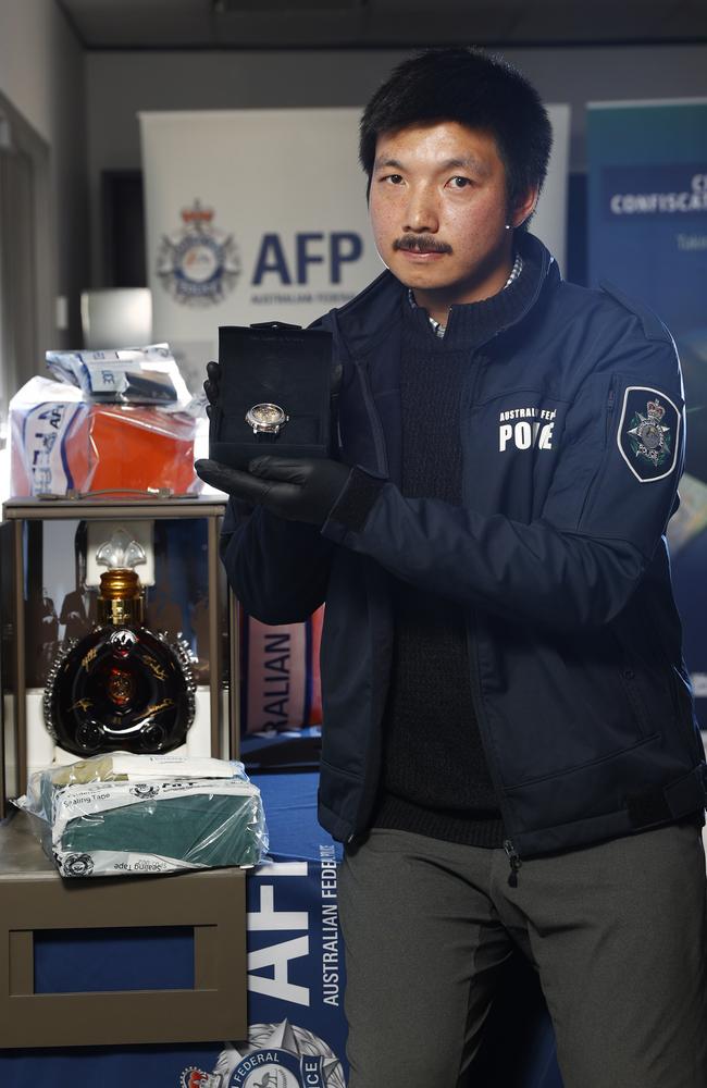 An AFP Investigator holds a rare Patek Philippe watch, worth well over a million dollars, as well as other items at the AFP’s Sydney headquarters. Picture: Richard Dobson