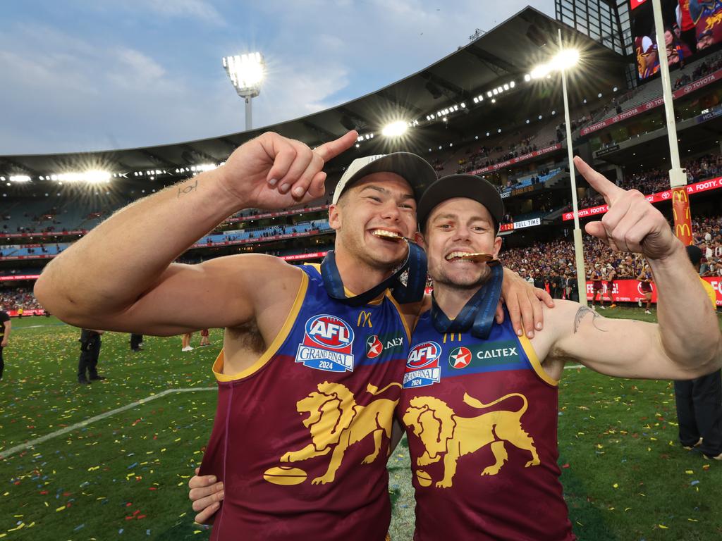 Cam Rayner and Lachie Neale bite their Premiership Medals. Picture: David Caird