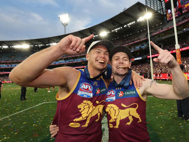 Cam Rayner and Lachie Neale bite their Premiership Medals. Picture: David Caird