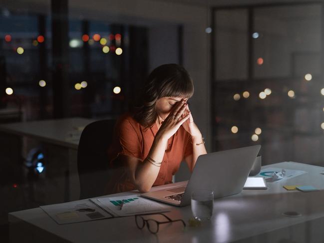 Shot of a young businesswoman looking stressed out while working on a laptop in an office at night