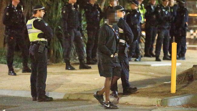 Police watch as youths gather outside St Kilda McDonalds. Picture: Mark Stewart