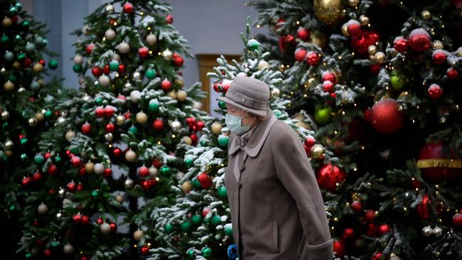 A woman walks past Christmas trees in Moscow. Picture: AFP