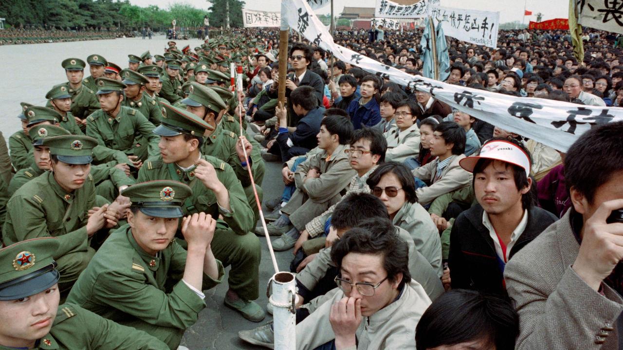 Pro-democracy students sit on the ground face-to-face with policemen outside the Great Hall of the People at Tiananmen Square in Beijing on April 22, 1989. Picture: Catherine Henriette / AFP