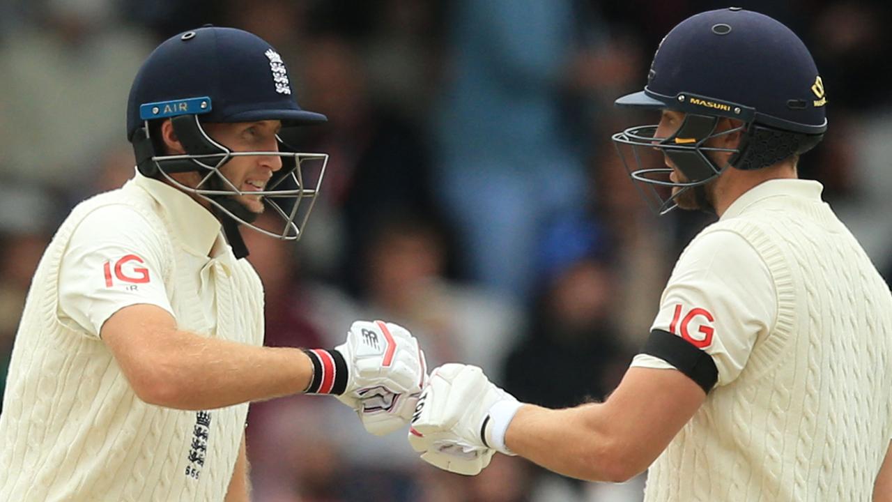 England's captain Joe Root (L) and England's Dawid Malan (R) touch gloves as they talk between overs on the second day of the third cricket Test match between England and India at Headingley cricket ground in Leeds, northern England, on August 26, 2021. (Photo by Lindsey Parnaby / AFP) / RESTRICTED TO EDITORIAL USE. NO ASSOCIATION WITH DIRECT COMPETITOR OF SPONSOR, PARTNER, OR SUPPLIER OF THE ECB
