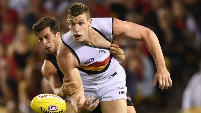 Josh Jenkins of the Crows handballs while being tackled by Kyle Langford of the Bombers during the round one clash between Essendon and Adelaide Crows at Etihad Stadium. Picture: GETTY IMAGES