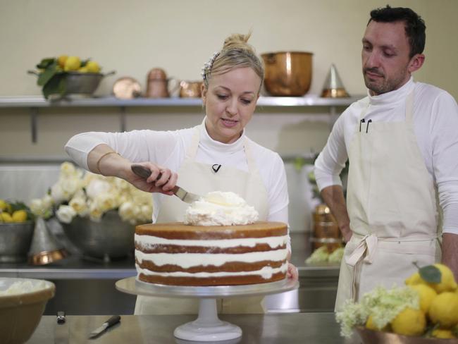 Claire Ptak, owner of Violet Bakery and head baker Izaak Adams put the finishing touches to one tier of the cake for the royal wedding. Picture: Hannah McKay/Pool Photo/AP