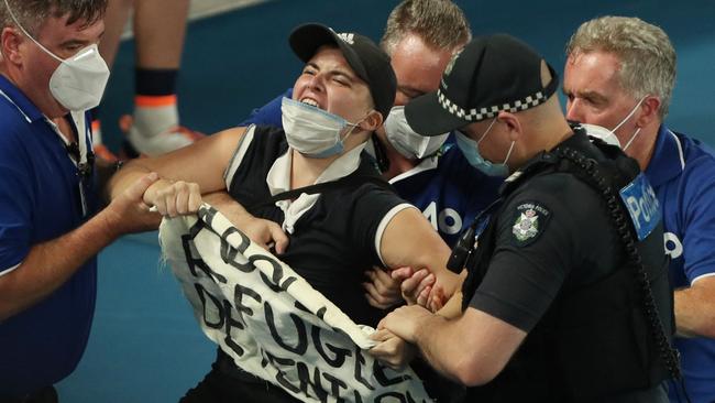 Security tackles the court invader. Picture: AFP