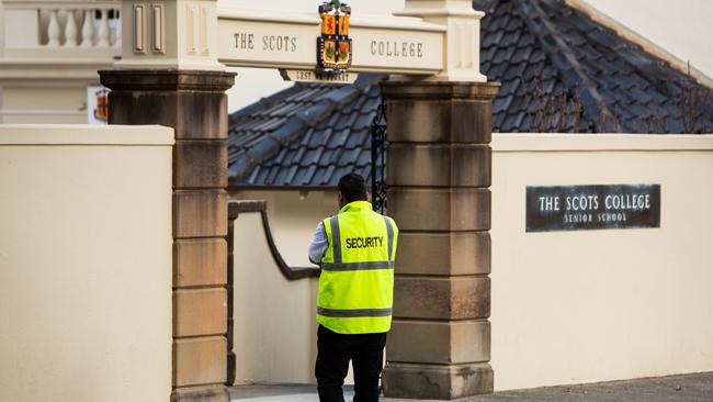 A security guard patrols outside the prestigious Scots College in Bellevue Hill, where damage by students participating in muck-up day activities was reported.