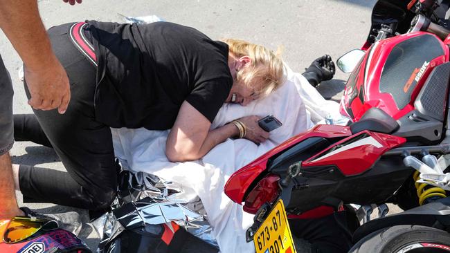 A woman weeps over the covered corpse of her nephew who was shot dead in the southern city of Sderot. Picture: AFP