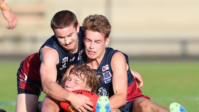 Castlemaine’s Zach Greeves is outnumbered by two Sandhurst opponents.