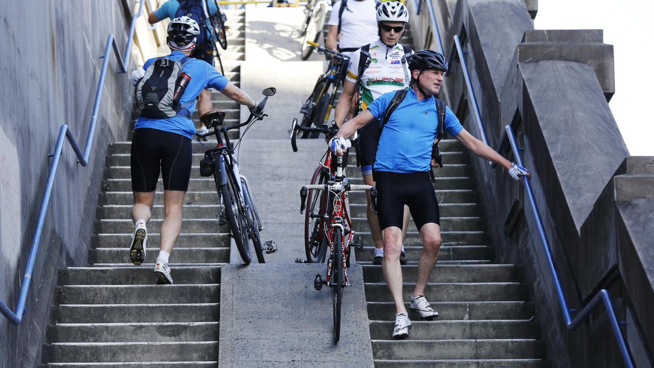 Cyclists walking up and down the steps to the Harbour Bridge bikeway.