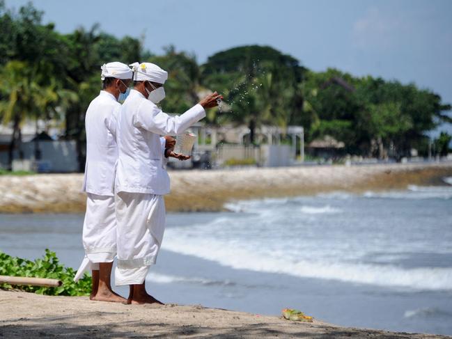 Balinese people pray during a Melasti prayer ceremony, a purification festival held several days before Nyepi, the day of silence which marks the Hindu new year on March 14 at Kuta beach. Picture: AFP