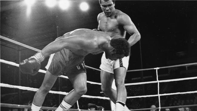 Challenger Muhammad Ali watches as defending world champion George Foreman goes down to the canvas in the eighth round of their WBA/WBC championship match in Kinshasa, Zaire.