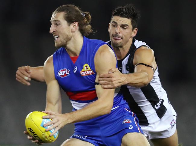 AFL Round 1. Western Bulldogs v Collingwood at Marvel Stadium..  21/03/2020.  Marcus Bontempelli of the Bulldogs looks to clear as Scott Pendlebury of the Magpies tackles   . Pic: Michael Klein