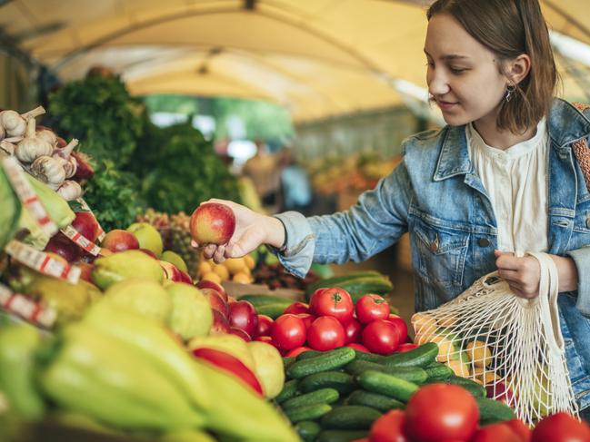 Teenager holding ecologically friendly reusable bag with fruit and vegetables generic istock